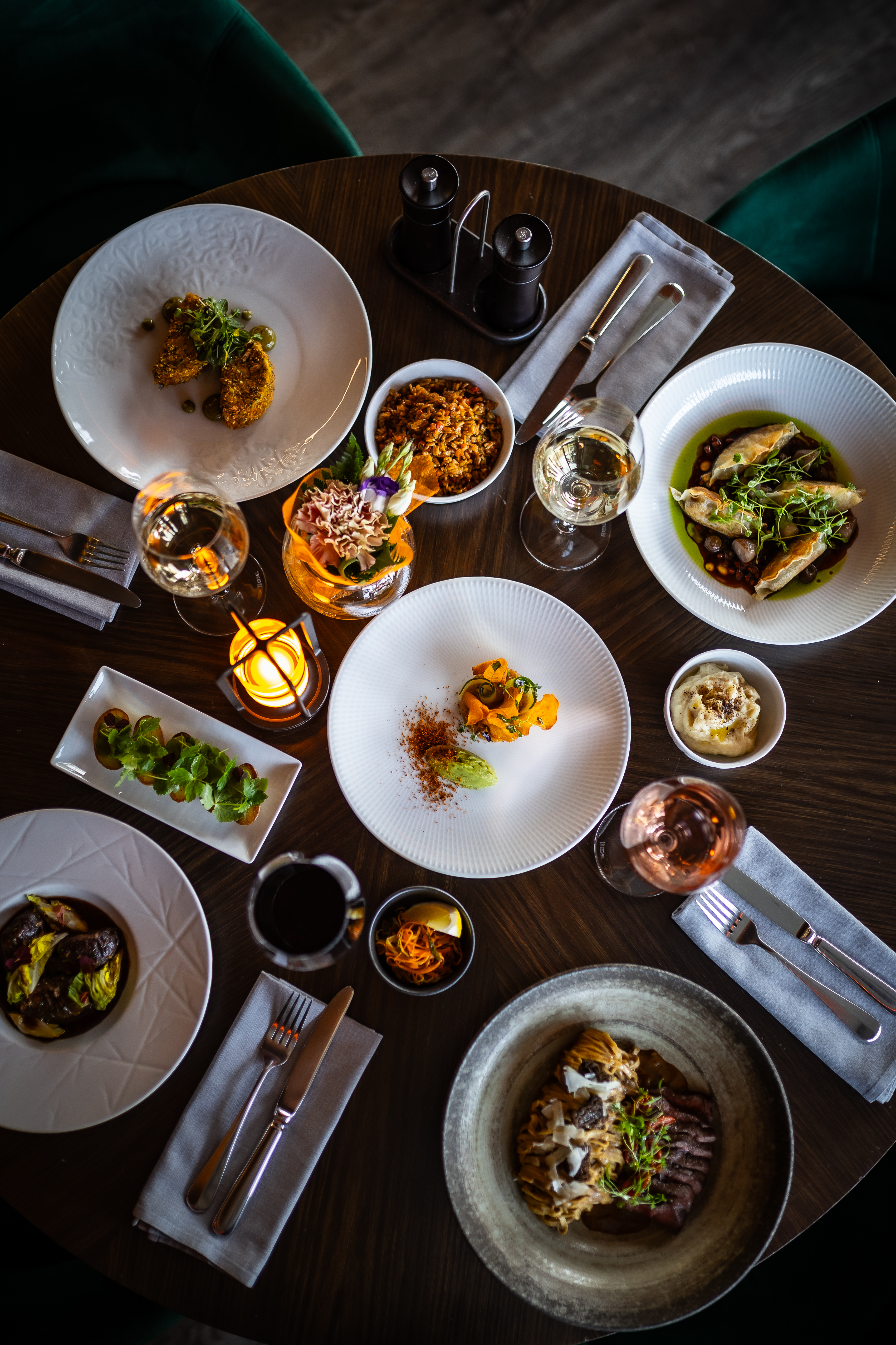 Next Bistro enteriőr: smaragdzöld bársony boxok, aranygömb csillárok, boros fal